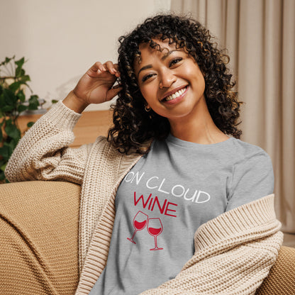 Woman smiling and wearing Women's Relaxed T-Shirt with "On Cloud Wine" text and two wine glasses, perfect for casual outings.